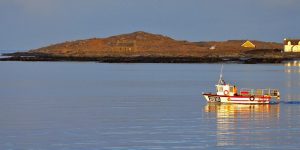 Photo of a small fishing boat on the water in the evening light